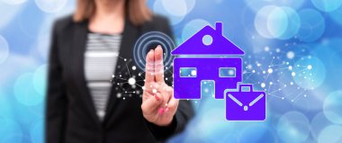 Kadın dokunmatik ekranda ev konseptine parmaklarıyla dokunuyor.