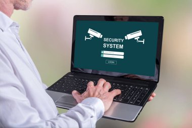 Ekranda güvenlik sistemi konsepti olan bir dizüstü bilgisayar kullanan adam