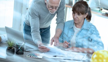 Yeni inşaat projesinde çalışan ve dijital tablet kullanan mimarlar; ışık efekti