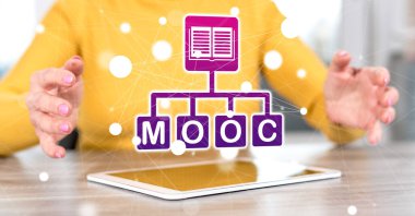 Arka planda bir kadının elleri arasında mooc kavramı olan dijital tablet