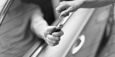 Woman handing another person automobile keys, geometric pattern