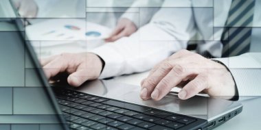 İşadamı dizüstü bilgisayarında, ofisinde, geometrik desende daktilo yazıyor.