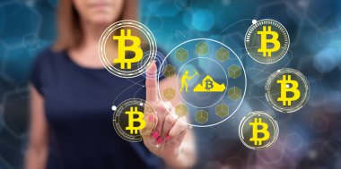 Kadın dokunmatik ekranda bitcoin madenciliği kavramına parmağıyla dokunuyor.