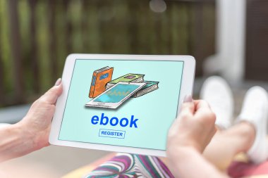 Kadın eli e-kitap konseptli bir tablet tutuyor.