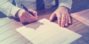 İşadamı ofiste bir belge imzalıyor, geometrik desen