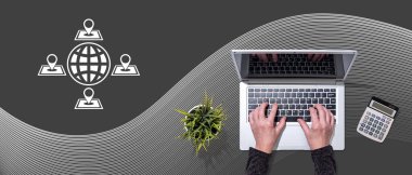 Küreselleşme kavramının sembolü olan dizüstü bilgisayar kullanan ellerin üst görünümü