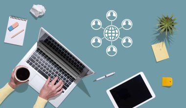 Küreselleşme kavramının sembolü olan dizüstü bilgisayar kullanan ellerin üst görünümü