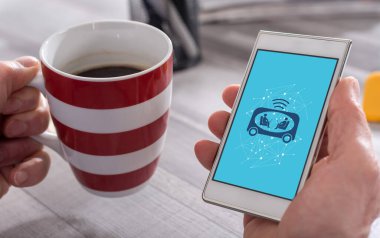 Otomobil konsepti olan akıllı telefonu elinde tutan bir erkek.