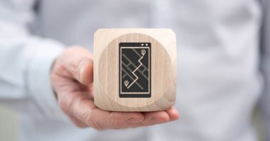 Elinde GPS konseptinin sembolü olan tahta bir küp var.