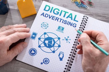 Masaya yerleştirilmiş bir not defterine dijital reklam konsepti