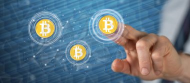 Bir adam dokunmatik ekranda bitcoin para kavramına parmağıyla dokunuyor