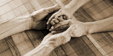 Couple holding their hands on wooden background, geometric pattern
