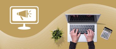 Toplumsal pazarlama kavramının sembolü olan dizüstü bilgisayar kullanan ellerin üst görünümü