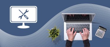 Sistem bakım kavramının sembolü olan dizüstü bilgisayar kullanan ellerin üst görünümü