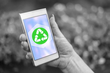 Geri dönüşüm kavramı ile bir akıllı telefon tutarak el