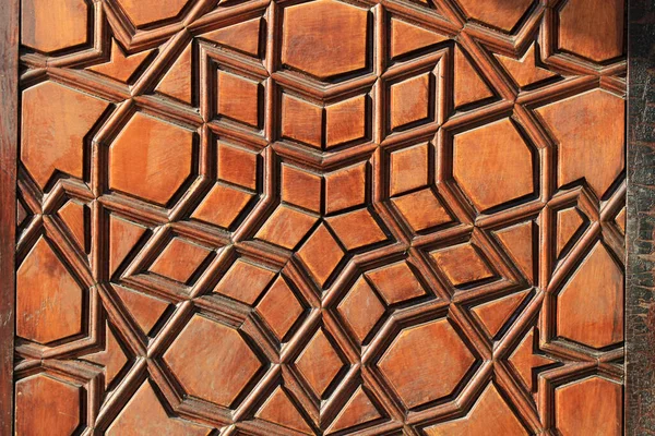 stock image An old handcrafted wooden door. No nails were used in the construction of the door. There are geometric motifs on the door.