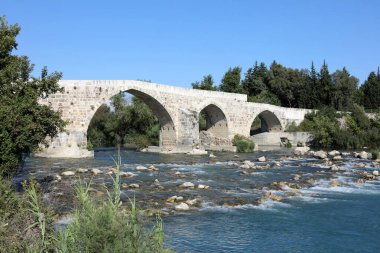 Aspendos Köprüsü ilk kez Roma döneminde inşa edildi. Deprem sonucu çöken köprü, 13. yüzyılda Seljuklar tarafından yeniden inşa edildi. Antalya, Türkiye.