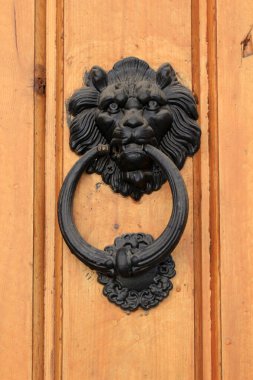 Aslan şeklinde kapı tokmağı. Ahşap bir kapının üzerinde siyah bir kapı tokmağı var. Sheki, Azerbaycan.