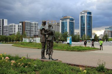 Şehir merkezinde bir park var. Parktaki genç bir oğlan ve kızın heykeli. Astana, Kazakistan.