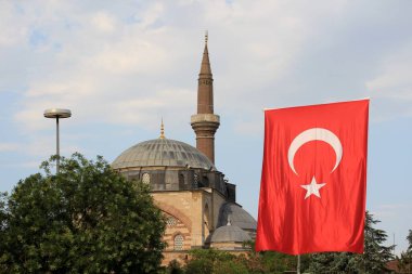 Serafeddin Camii 17. yüzyılda Osmanlı döneminde inşa edilmiştir. Camiinin kubbesi ve Türk bayrağıyla bir minare manzarası. Konya, Türkiye.