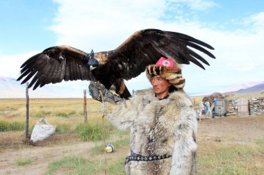 Kazak kartal eğitmenleri. Orta Asya 'da kartal yavruları yuvadan alınır ve avlanmak için evcilleştirilir. Kartallarla turistler için de gösteri yapıyorlar. Tolbo, Moğolistan.