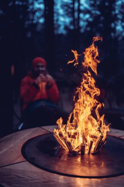 Kamp ateşinin yanında oturan adamlar.