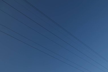 Black wires, against the background of a dark, cold, blue night sky.