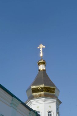  Güneş ışığıyla aydınlanan haçlı kilise kubbesi maviliğe karşı. 