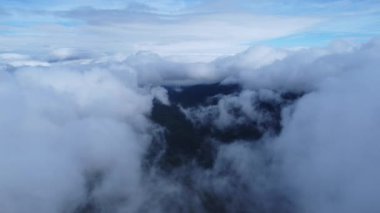 Sabahları bulutlu güzel gökyüzü manzarası. Mavi gökyüzünün üstündeki güneş parlayan bulutların havadan görünüşü. Dağın tepesindeki sis denizi manzarası. Gökyüzü doğa arkaplanı.