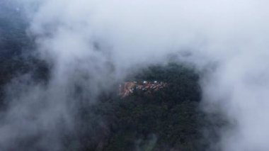 Sabahları sisli tropikal ormanlarda zaman kaybı. Tayland 'da kış boyunca sisli bir platoda kırsal bir köyde uçan bir dronun hava görüntüsü. Doğal manzara arka planı.