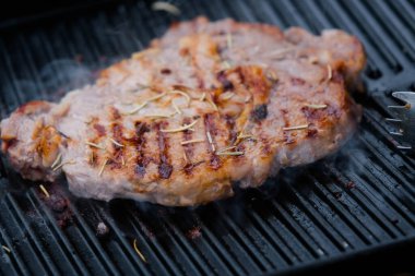 Izgarada ızgara biftek ve baharatlı duman..