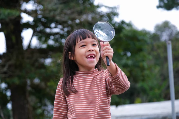 可爱的小女孩在户外用放大镜探索大自然 孩子们用放大镜在森林里玩耍 教育和发现概念 — 图库照片