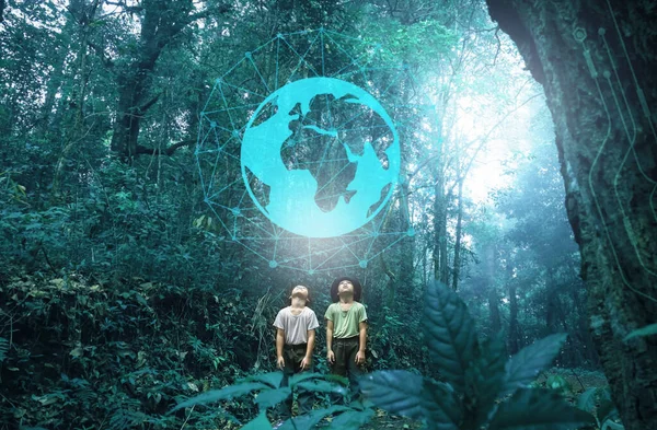İki kardeş, güzel yağmur ormanları arka planındaki dünya ikonuna bakmak için heyecanlıydılar. Ormanda yürüyüş macerasına çıkmış bir aile. Teknoloji ve hayal gücü kavramları