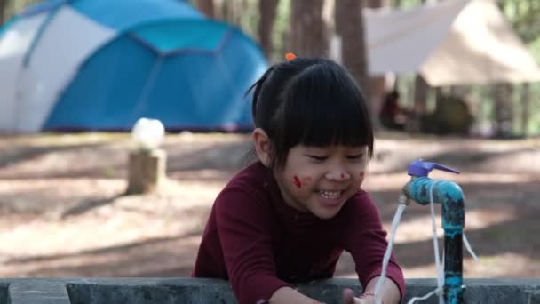 귀여운 아시아인 공원에서 근처에서 색칠을 소녀는 도꼭지 밑에서 씻었다 깨끗하고 — 비디오