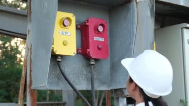 Mining engineer wearing a white helmet surveying her work place.