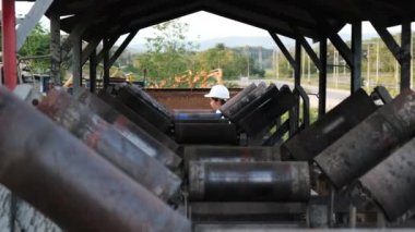 Mining engineer wearing a white helmet surveying her work place.