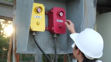 Portrait of professional Asian electrical engineer turning on the switches.