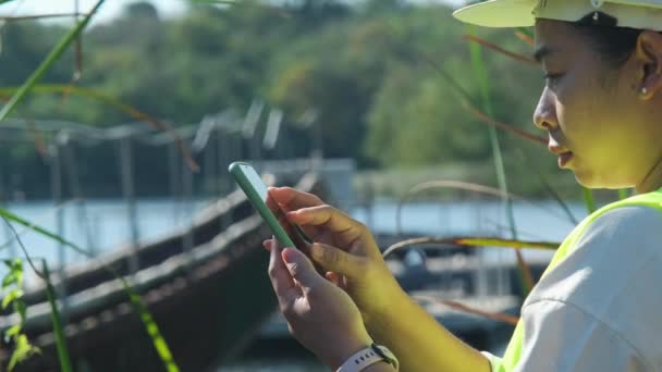環境エンジニアは 携帯電話を使用して貯水池の酸素濃度を分析する写真や記録データを撮影します 水と生態学の概念 — ストック動画