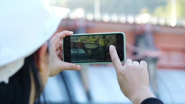 女性環境保護主義者は携帯電話を使って写真を撮り ダムの水を汚染物質のために分析したデータを記録する 水と生態学の概念 — ストック動画