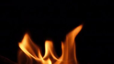 Close-up of burning paper with fire element isolated on black background. flame stream