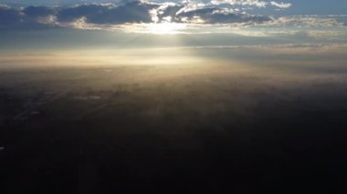 Ormanla kaplı sisli tepelerin hava manzarası. Gün doğumunda dağlarda güzel bir manzara. Ormandaki sisli dağda renkli bir gün doğumu. Şafak vakti dağlarda.