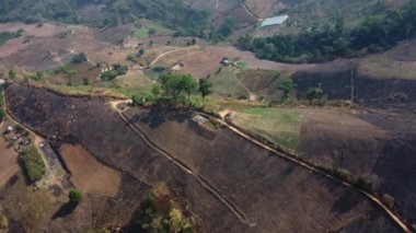 Bitki yetiştirmek için insanlar tarafından yok edilen dağ. Yanan ormanların sisleriyle kaplı dağların havadan görünüşü. Yoğun sisli ve PM2.5 ile kaplı alanlar Hava kirliliği ve ekolojik sorunlar
