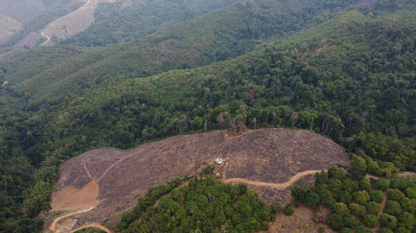 Mountain destroyed by human for cultivate plants. Aerial view of mountains covered in haze from burning forests. Areas with dense smog and covered with PM2.5. Air pollution and ecological problems