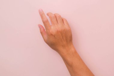 Erkek eli, pembe arka planda tek parmakla birbirine dokunuyor. Dokunma panelini çalıştırmak için eller.