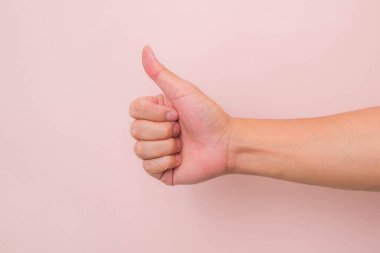Pembe arka planda erkek elinin baş parmak işareti görünümü kapat.