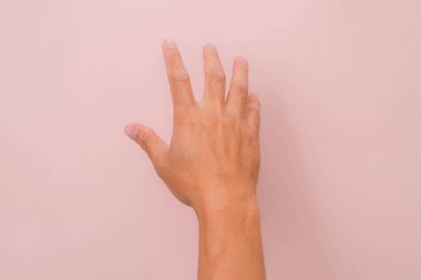 Erkek eli pembe arka planda izole edilmiş bir şekilde yardım etmeye ya da almaya hazır şekilde uzanır. Kurtuluşa uzanan ellere yardım etmek.