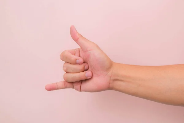 Call me hand sign or gesture isolated on pink background.
