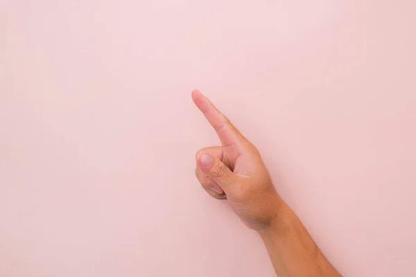 Close-up of male hand pointing isolated on pink background. Man\'s hand touching or pointing to something