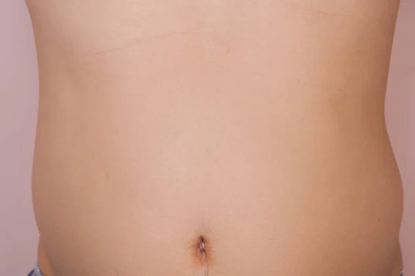男人的肥胖腹部被粉红色的背景隔离了 体重增加的年轻人 肚子大 — 图库照片