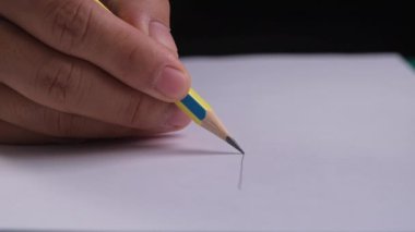Grafit kalem beyaz arkaplan kağıdına düz çizgiler çiziyor. Tahta kalemle çizilmiş sanatçı eli kağıda düz çizgiler çiziyor..